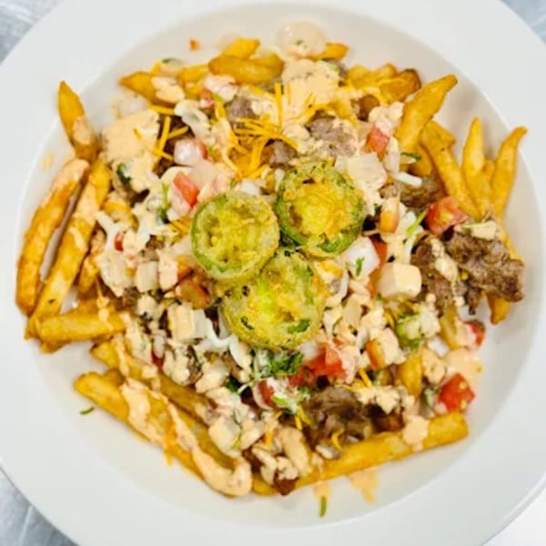 Sims Cafe's loaded fries topped with meat, cheese, tomatoes, onions, and jalapeños.