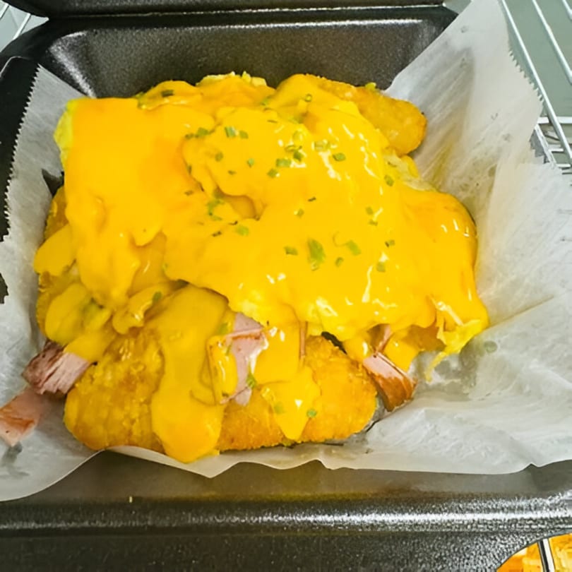 Sims Cafe's breakfast croissant with ham, eggs, and melted cheese, topped with chives.