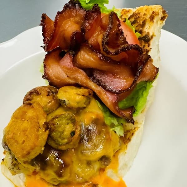 A Sims Cafe sandwich with crispy bacon, lettuce, tomato, and melted cheese with jalapeños.
