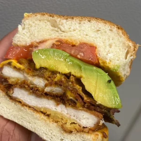 A cross-section of a Sims Cafe sandwich with fried chicken, bacon, avocado, and tomato.
